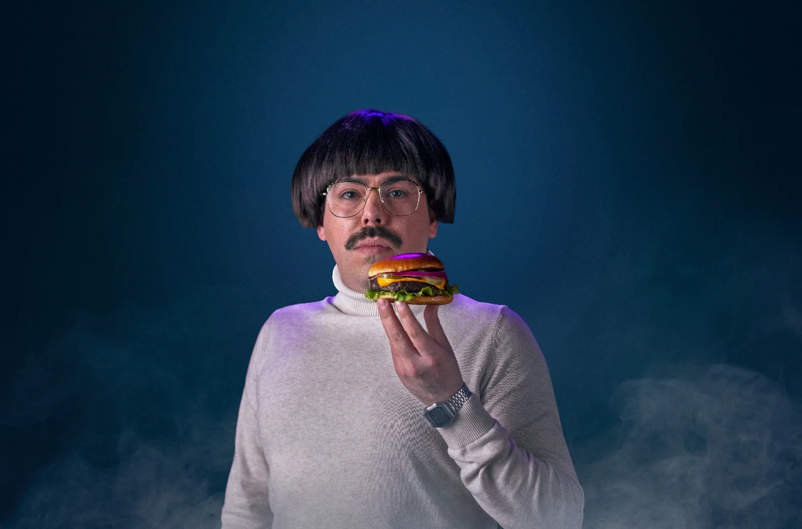 Fotografía publicitaría para marca de hamburguesas veganas con un hombre sosteniendo una hamburguesa